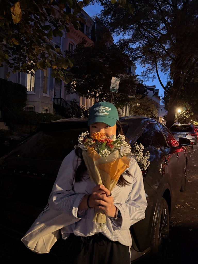 Person holding flowers at night on a residential street