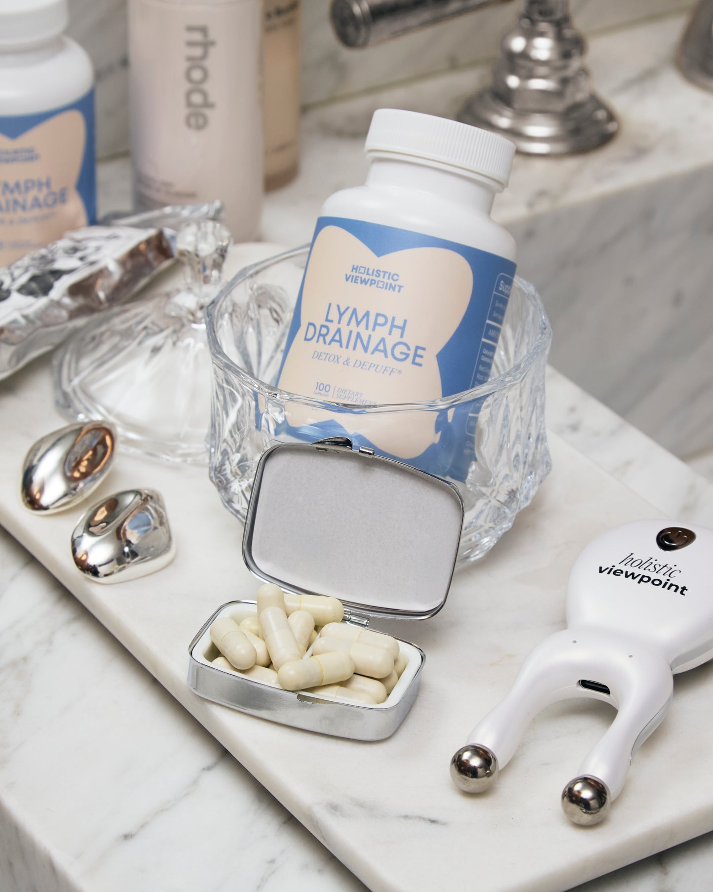 Bottle labeled 'lymph drainage' with a small container of capsules on a marble surface.