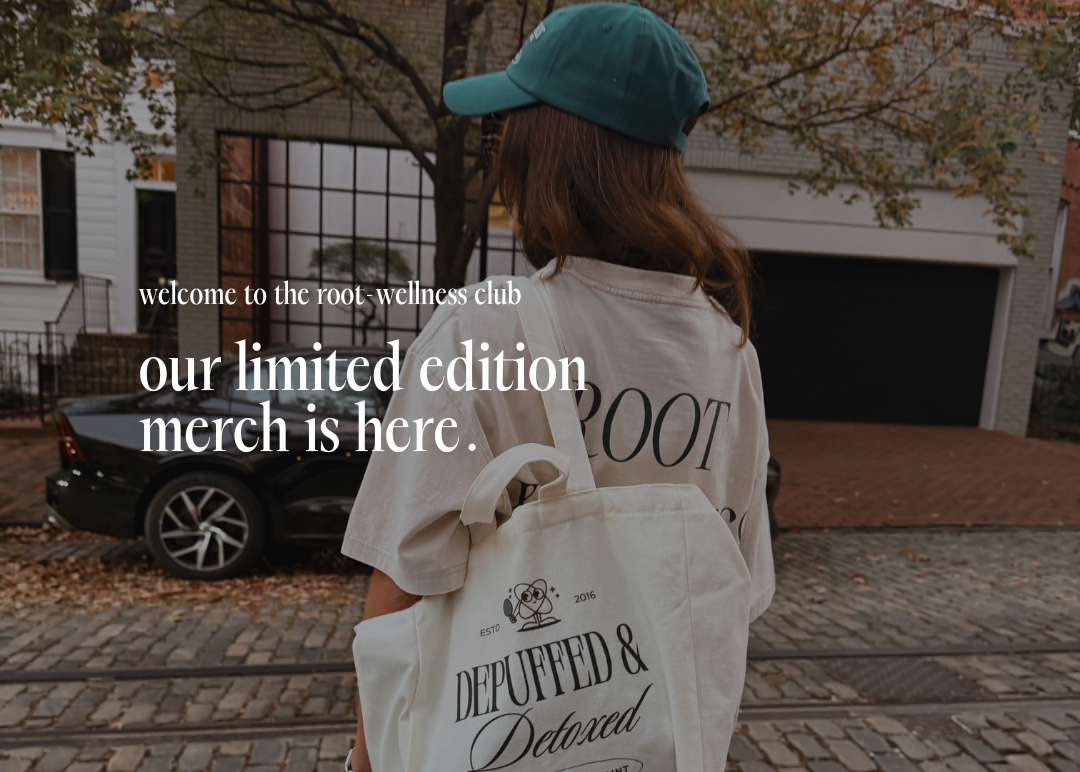 Person holding a tote bag with text 'welcome to the root wellness club' and 'our limited edition merch is here'.